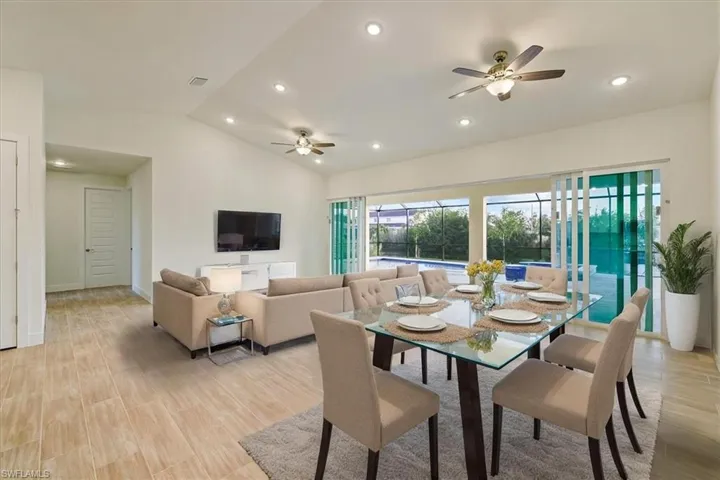 Dining room featuring ceiling fan, lofted ceiling, light wood finished floors, and recessed lighting
