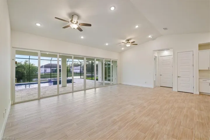 Empty room with ceiling fan, recessed lighting, wood tiled floors, and lofted ceiling