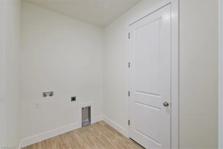 Washroom with wood finish floors, hookup for an electric dryer, and washer hookup