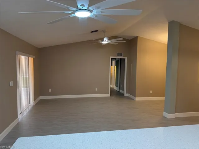 Spare room featuring lofted ceiling and ceiling fan