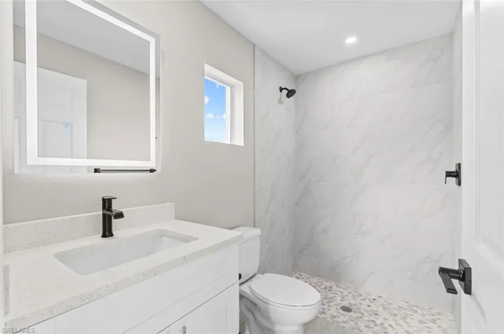 Bathroom featuring vanity and a tile shower