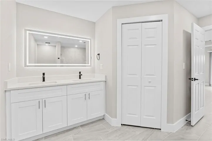 Full bathroom featuring a closet and double vanity