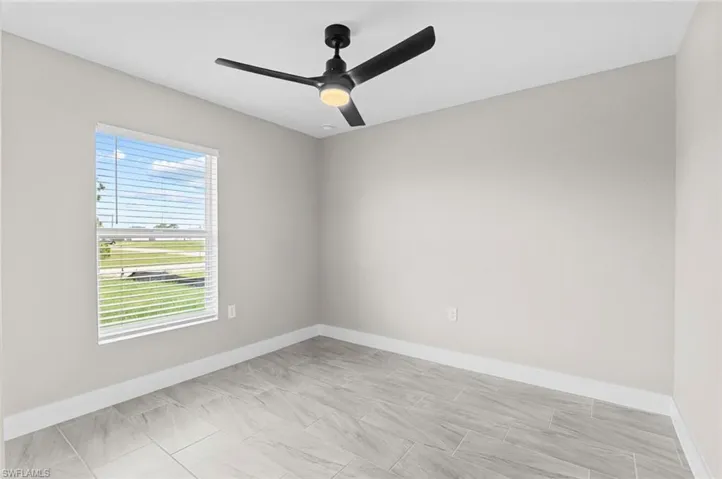 Unfurnished room featuring baseboards and a ceiling fan