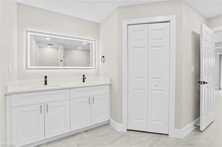 Full bathroom featuring a closet and double vanity