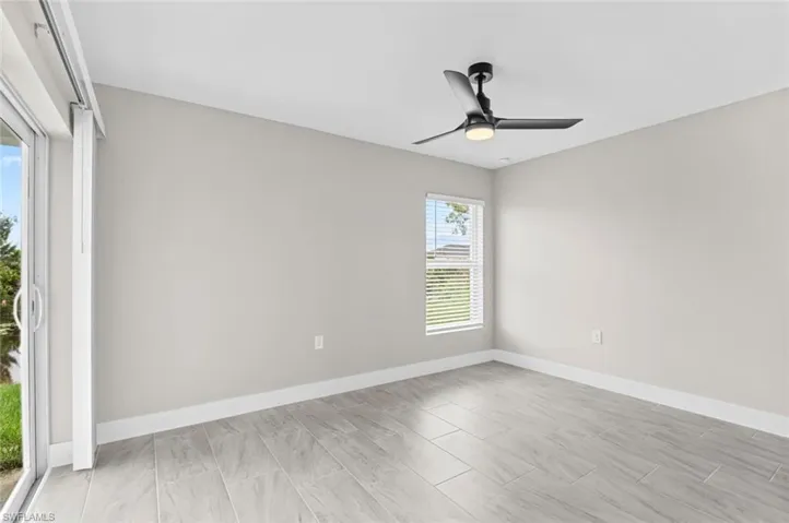 Empty room with baseboards and a ceiling fan