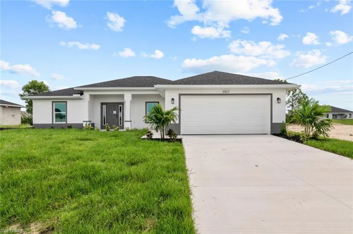 View of front of home featuring stucco siding, concrete driveway, a garage, a front yard, and roof with shingles