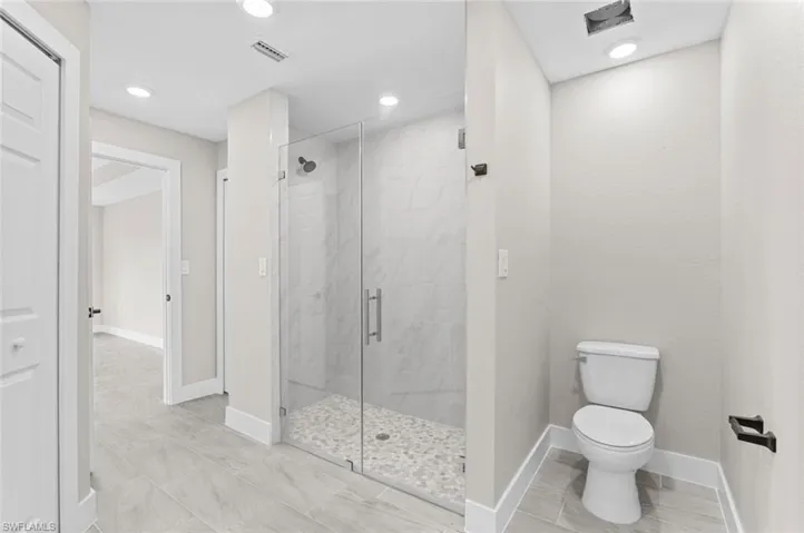 Full bath with a shower stall and recessed lighting