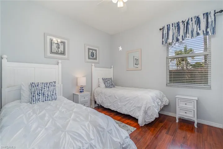 Bedroom featuring dark wood-type flooring and baseboards