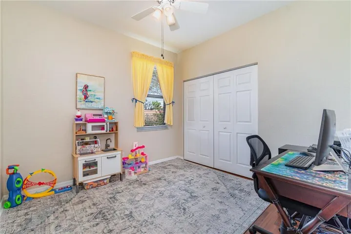 Home office with ceiling fan and baseboards