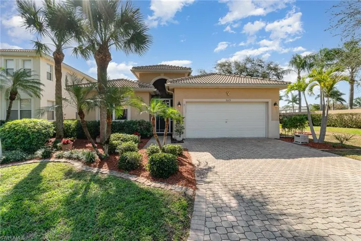 Mediterranean / spanish-style home featuring a garage, a tiled roof, decorative driveway, stucco siding, and a front yard