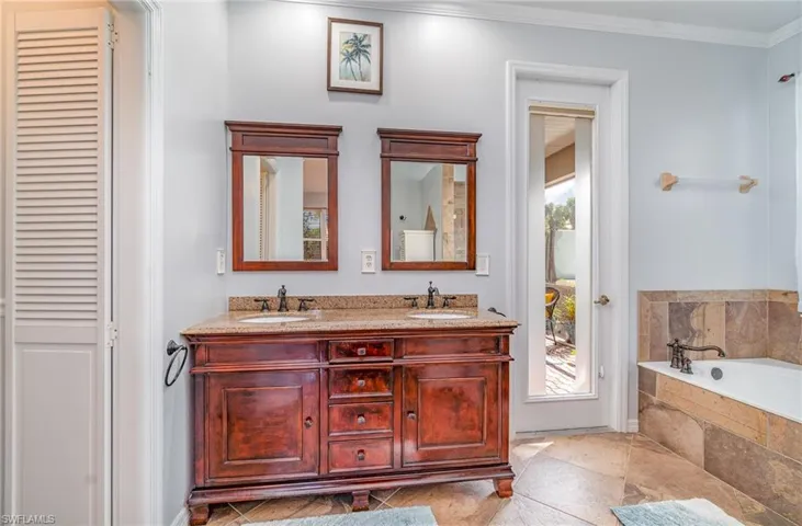 Full bath featuring plenty of natural light, a sink, and crown molding