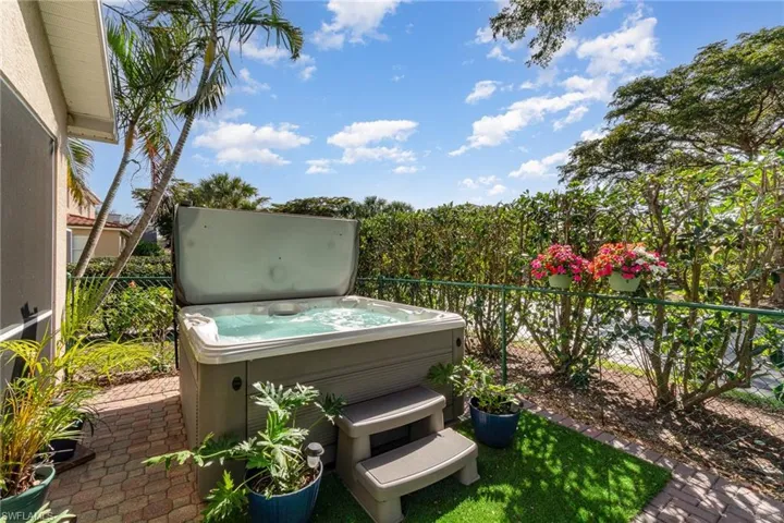 View of patio / terrace with a hot tub and fence