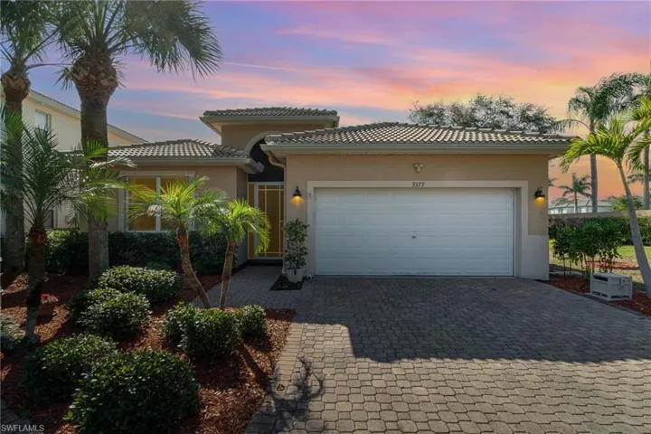 Mediterranean / spanish-style home with a garage, decorative driveway, a tile roof, and stucco siding