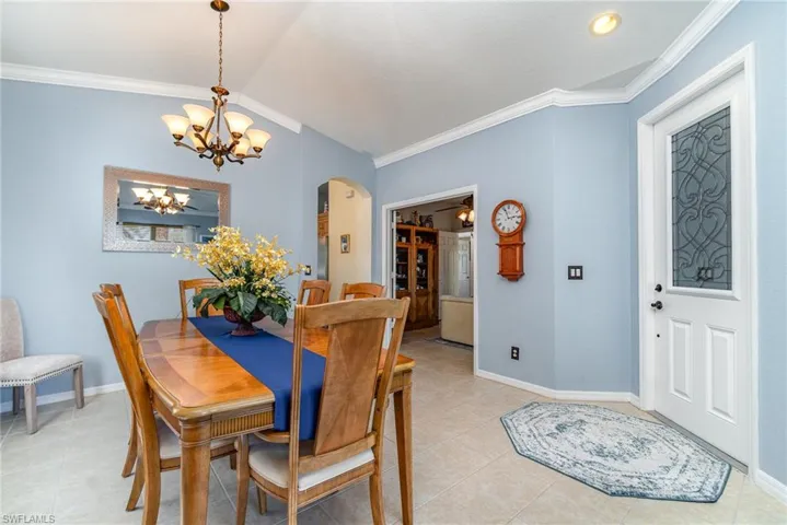 Dining area featuring ornamental molding, arched walkways, and baseboards