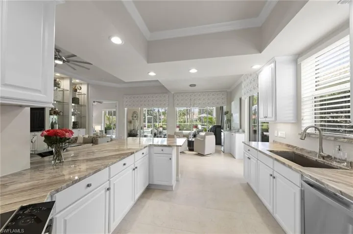 Kitchen featuring white shaker-style cabinetry, expansive stone countertops, recessed lighting, and a neutral tile floor