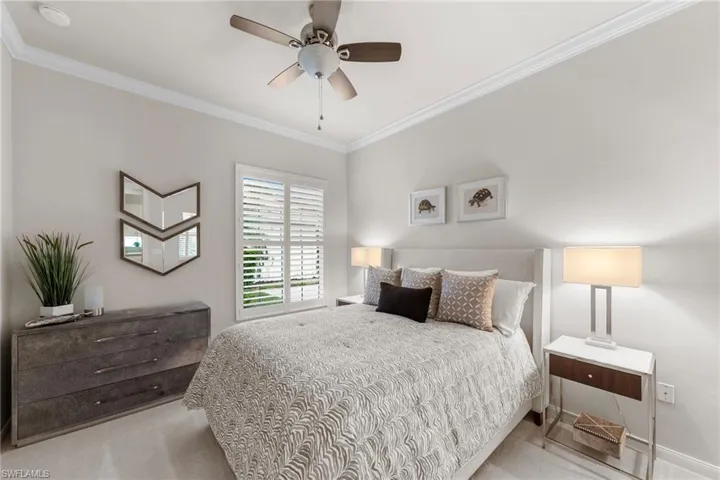 Bedroom featuring crown molding, neutral wall finishes, plantation shutters, and a central ceiling fan