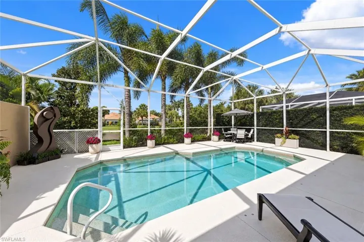 Screen-enclosed swimming pool featuring a multi-level step entry, concrete decking, and mature landscaping