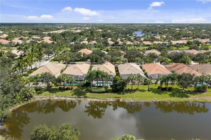 Aerial perspective of waterfront properties featuring screen-enclosed swimming pools, manicured landscaping, and mature palm trees