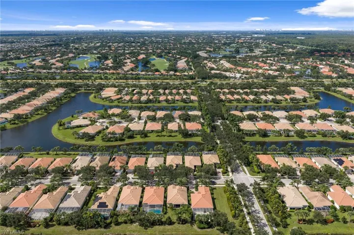 Aerial perspective of a planned community featuring multi-phase housing, interconnected waterways, and mature landscaping