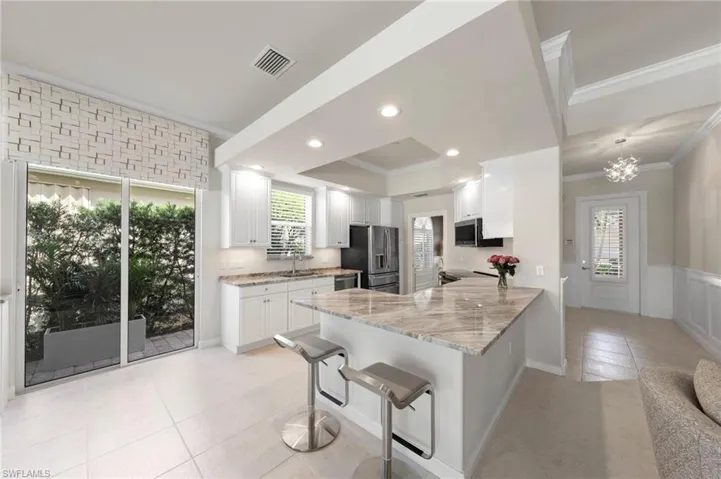 Kitchen featuring white cabinetry, stone-finish countertops, recessed lighting, tile flooring, and sliding glass doors