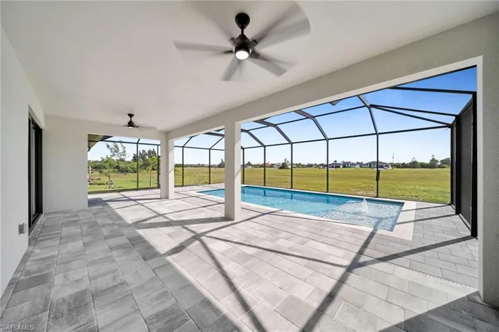 Outdoor pool featuring ceiling fan, a yard, a sunroom, a patio area, and a lanai