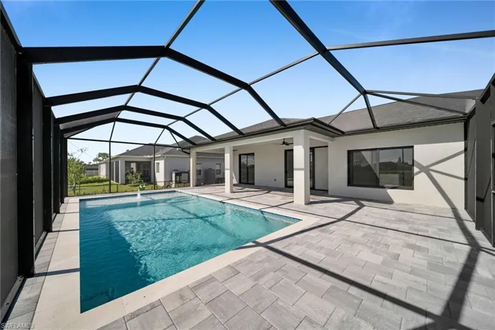 Swimming pool featuring a sunroom, ceiling fan, glass enclosure, and a patio