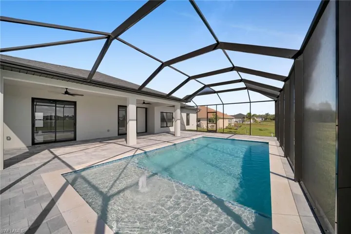 Swimming pool featuring a sunroom, a ceiling fan, glass enclosure, and a patio area
