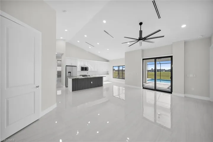 Unfurnished living room featuring high vaulted ceiling, a ceiling fan, and recessed lighting