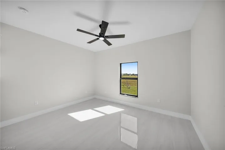 Spare room with baseboards and a ceiling fan