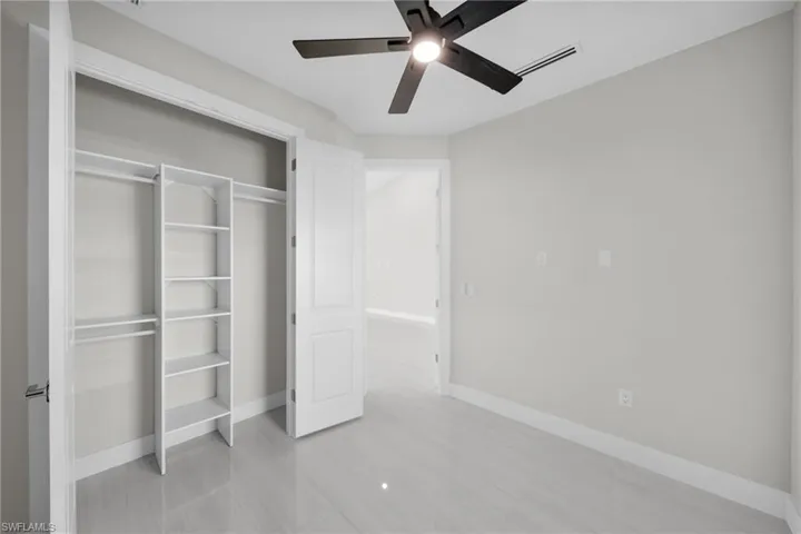 Unfurnished bedroom featuring ceiling fan and a closet
