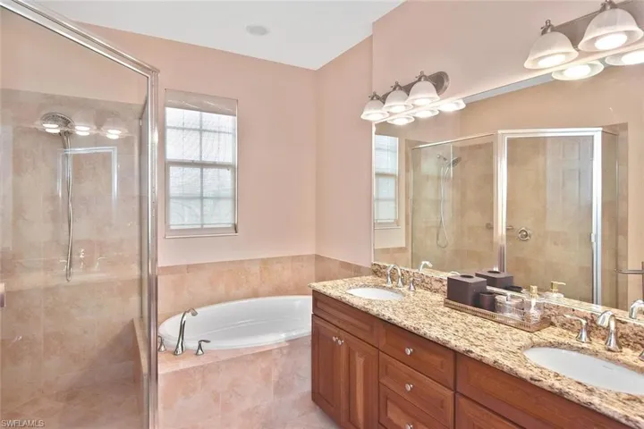 The ensuite bath has dual sinks, a walk-in shower, and a relaxing Roman tub.