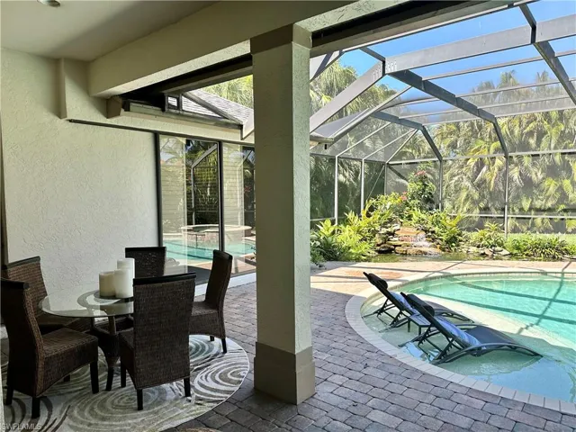 View of pool featuring longe shelf and patio area and a lanai
