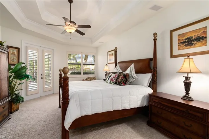Carpeted Master bedroom with a tray ceiling, french doors, ceiling fan, and access to exterior