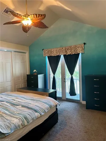 Guest house Bedroom featuring ceiling fan, a closet, vaulted ceiling,  and access to exterior