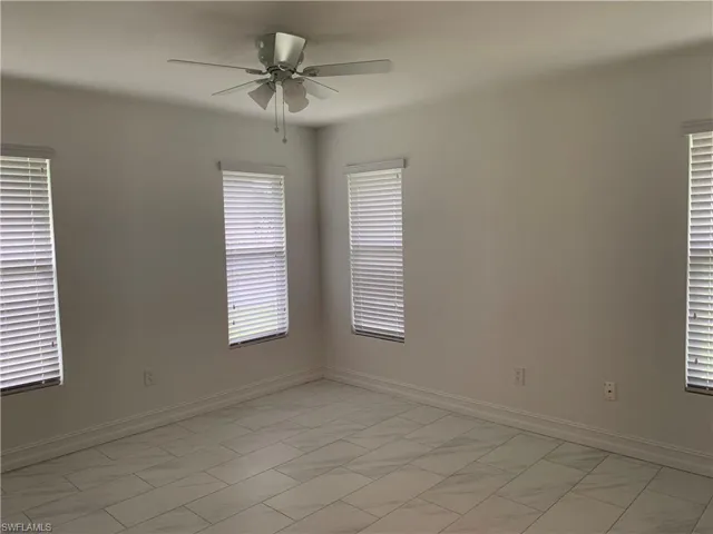Unfurnished room with a ceiling fan baseboards