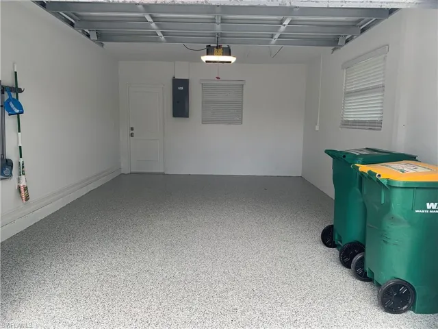 Garage featuring electric panel and a garage door opener