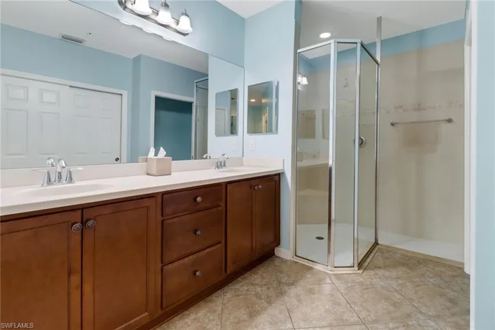 Bathroom featuring tile patterned floors, walk in shower, and vanity