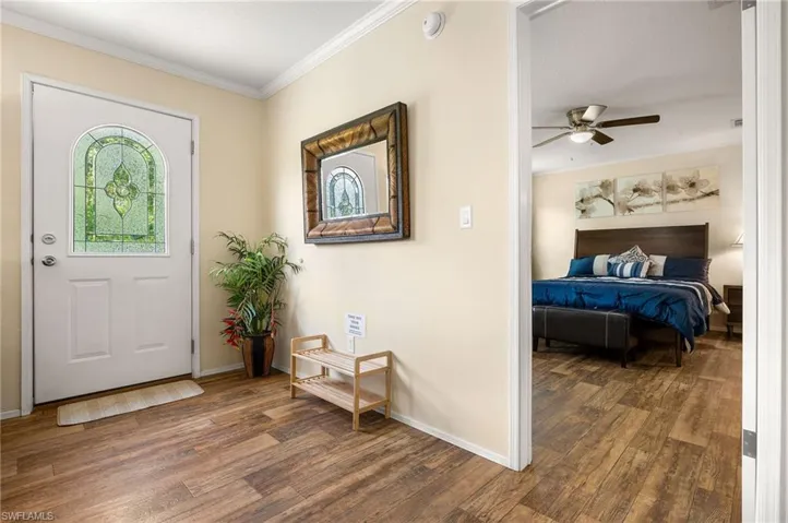 Foyer with ceiling fan, ornamental molding, and dark hardwood / wood-style flooring
