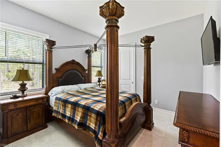 Bedroom with multiple windows and light tile floors