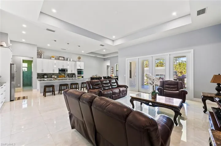Living room with a tray ceiling and light tile floors
