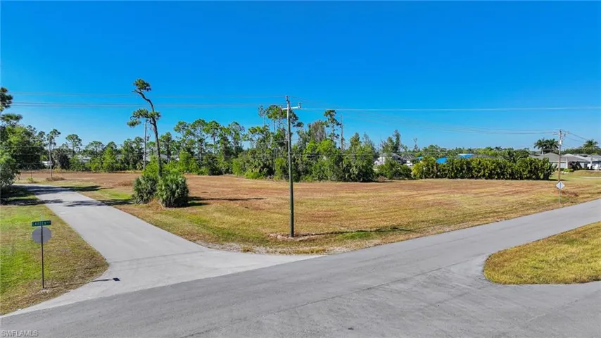 View of asphalt road with view of wooded area