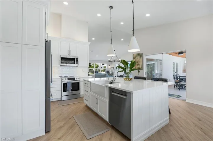 Kitchen with white cabinetry, appliances with stainless steel finishes, a center island with sink, pendant lighting, and recessed lighting
