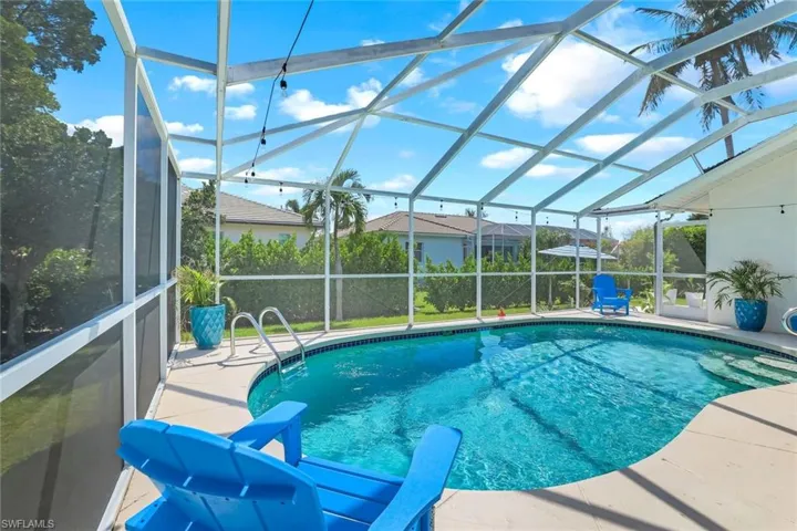 Swimming pool featuring glass enclosure, a sunroom, and a patio