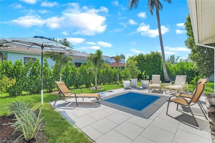 View of swimming pool with a patio and a yard