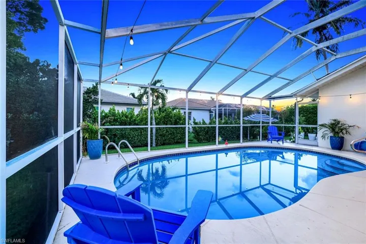 Outdoor pool featuring a sunroom, glass enclosure, and a patio