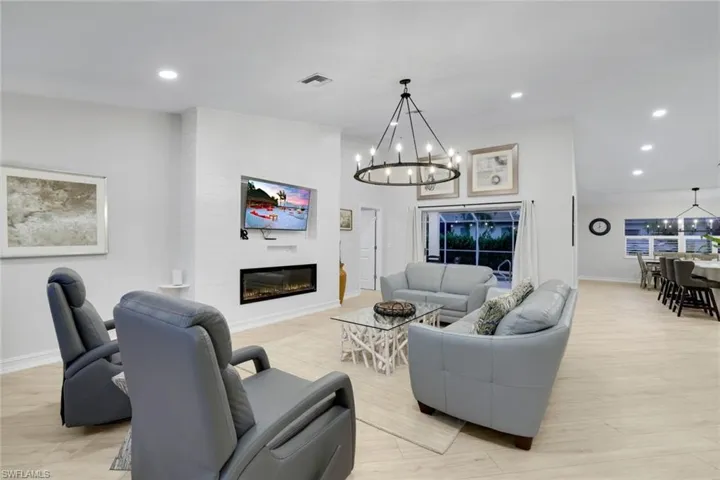 Living area featuring a chandelier, a fireplace, recessed lighting, and light wood finished floors