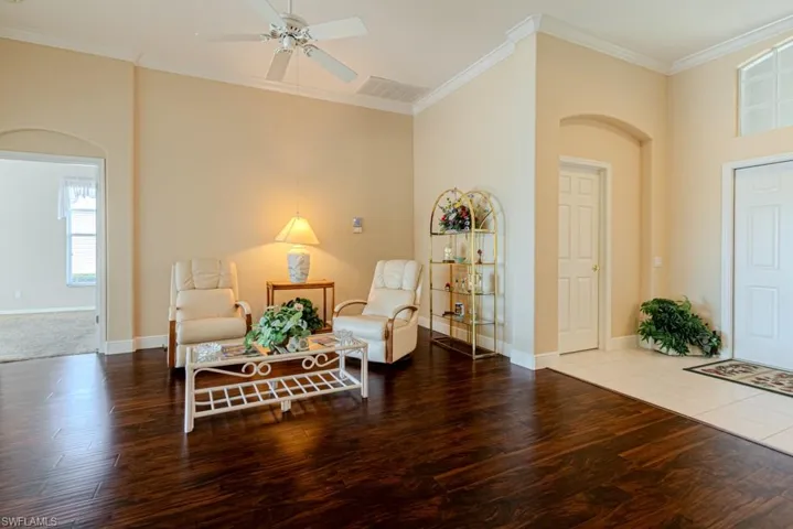 Living area featuring crown molding, hardwood / wood-style flooring, and ceiling fan