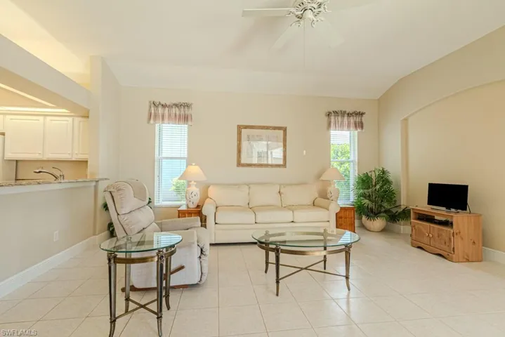 Living room featuring a healthy amount of sunlight, ceiling fan, and light tile floors