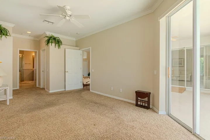 Unfurnished bedroom featuring access to exterior, ensuite bathroom, ceiling fan, crown molding, and light colored carpet
