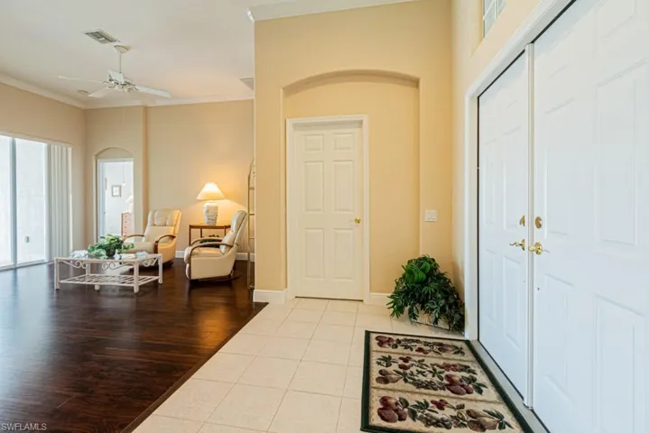 Tiled entryway with ornamental molding and ceiling fan